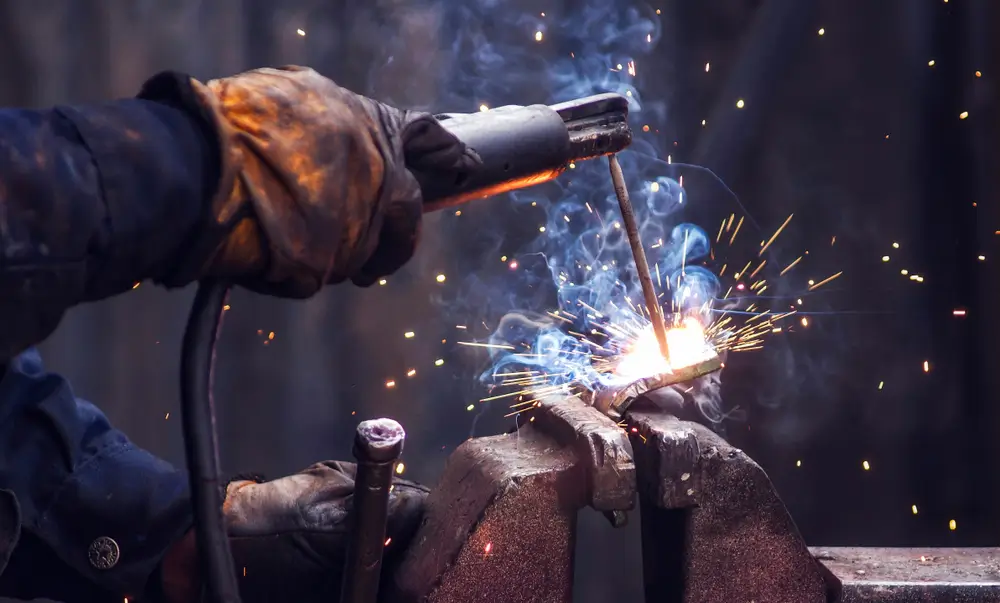 industry worker welding iron pieces
